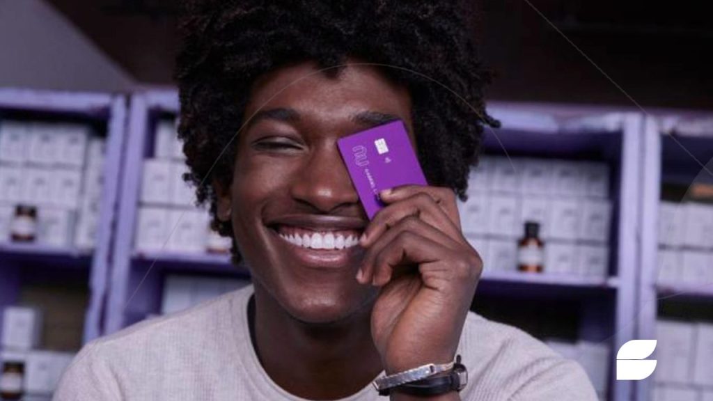 jovem negro segurando cartão nubank