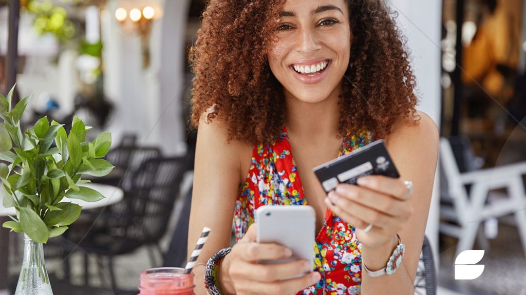 mulher segurando cartão e celular