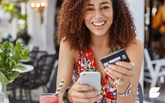 mulher segurando cartão e celular