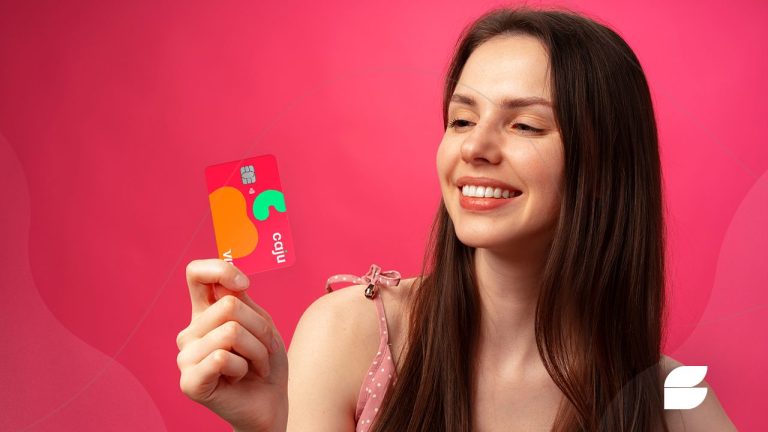 mulher segurando um cartão caju benefícios visa